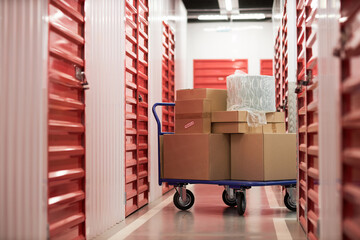 Cart with cardboard boxes in corridor of self-storage