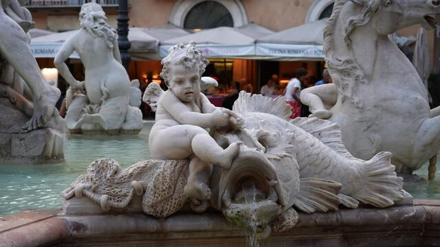 Detail shot of Rome 16th-century marble Neptune Fountain - Fontana del Nettuno on Piazza Navona, depicting mythological cherubs and Neptune fighting with an octopus. Shooting in slow motion.