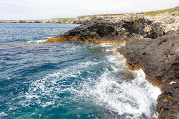 Cape Tarkhankut on the Crimean peninsula. The rocky coast of the Dzhangul Reserve in the Crimea. A sunny summer day. The Black Sea. Turquoise sea water.