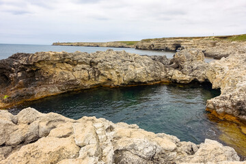 Cape Tarkhankut on the Crimean peninsula. The rocky coast of the Dzhangul Reserve in the Crimea. A sunny summer day. The Black Sea. Turquoise sea water.