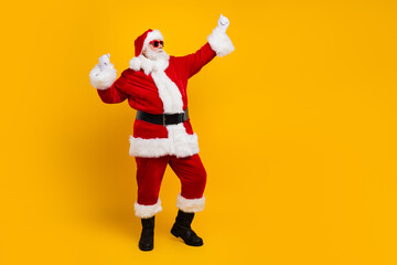 Fototapeta na wymiar Full length portrait of overjoyed charismatic santa raise fists success empty space christmas eve offer isolated on yellow color background