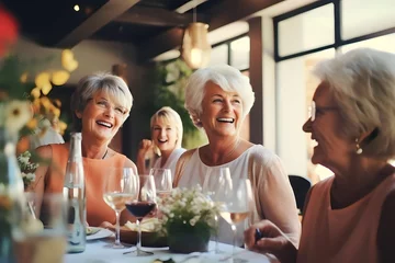 Keuken spatwand met foto Happy senior diverse women drinking wine and laughing together in restaurant © Salsabila Ariadina