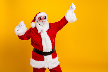Fototapeta na wymiar Portrait of delighted elderly santa raise fists empty space new year eve offer ad isolated on yellow color background