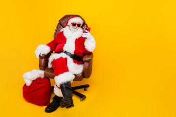 Full body photo of funny saint nicholas grandfather browsing smartphone searching eshopping xmas offers isolated on yellow color background