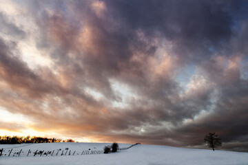 snowy landscape of a snowy countryside with a reddish sky