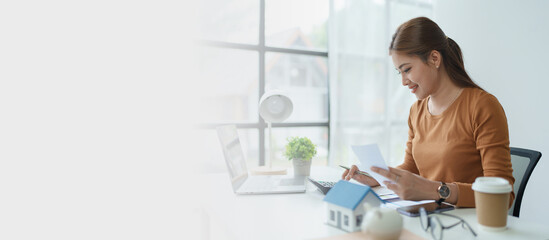 asian woman are using a calculator to calculate the loan period each month.