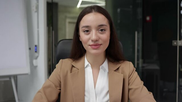 Young woman listening to webcam, participating in videoconference. Head shot portrait girl negotiating with clients using Video call nodding