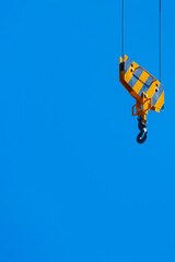 The yellow hook of a crane on a blue sky background.
Personal growth concept. - 681139224