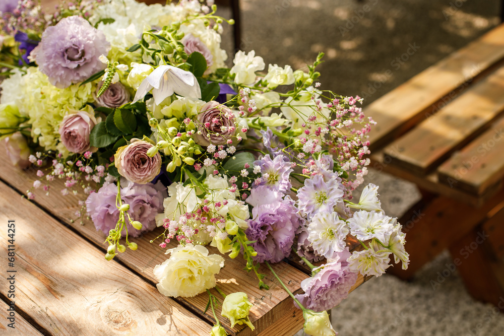 Wall mural Close up of a wedding table decoration with purple, green `and white flowers, candles. Wedding outdoor and floristic concept