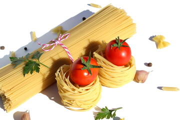 Knitted spaghetti lies on a white background with pasta nests and tomatoes.