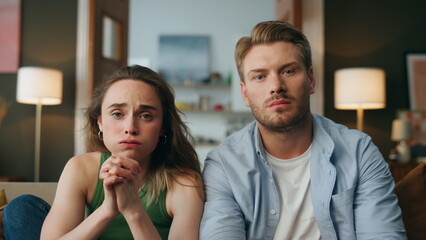 Worried pair watching movie living room zoom on. Nervous couple empathizing film