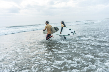 Two friends sprint toward the water. Boards in hand, wetsuits on, they're poised for a ride through...