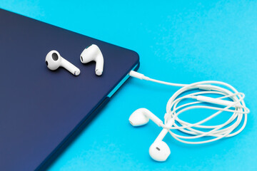 white wireless headphones lie on a laptop.