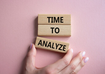 Time to Analyze symbol. Concept word Time to Analyze on wooden blocks. Businessman hand. Beautiful pink background. Business and Time to Analyze concept. Copy space