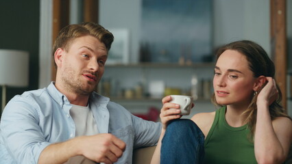 Talking duet drinking tea at sofa interior closeup. Calm woman sipping coffee - obrazy, fototapety, plakaty