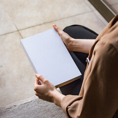 hands holding a blank book