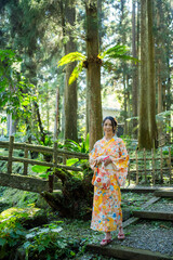 Asian woman try to wear Japanese kimono walk in the forest