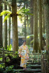Asian woman try to wear Japanese kimono walk in the forest