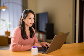 Woman use laptop computer for checking the daily supplement