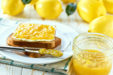 Delicious toast with lemon jam on the wooden kitchen table.