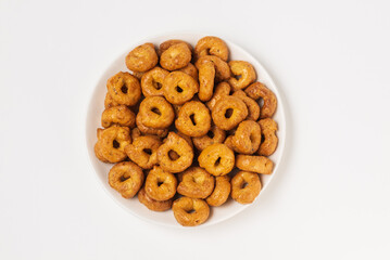 Traditional italian snacks taralli or tarallini in white plate isolated on white background, top view