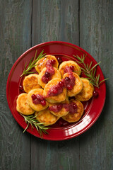 Delicious Cheese pancakes decorated with rosemary and cranberries, a homemade Christmas dessert