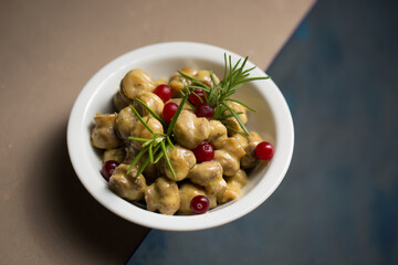 Small champignon mushrooms stewed in sour cream with rosemary and cranberries