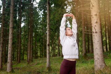 fit sporty woman doing stretching exercise in the forest, warm up exercises.