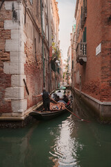 A serene gondola glides through the narrow canals of Venice, capturing the timeless beauty and charm of the city. Peaceful and tranquil, it evokes the picturesque waterways of Venice. © Aerial Film Studio