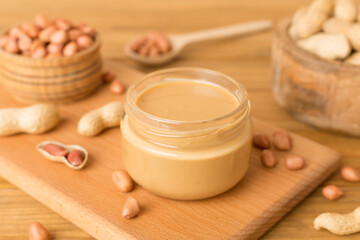 Fototapeta na wymiar Jar of peanut butter on wooden table