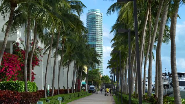 People walking on pedestrian street in South Pointe Park alongside Biscayne Bay in Marina district in Florida, USA. Recreational area in modern American megapolis.