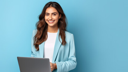 Smiling woman holding a laptop against a blue background.