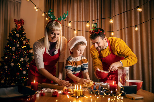 A happy family preparing homemade christmas gingerbread cookies at cozy home on christmas and new year.