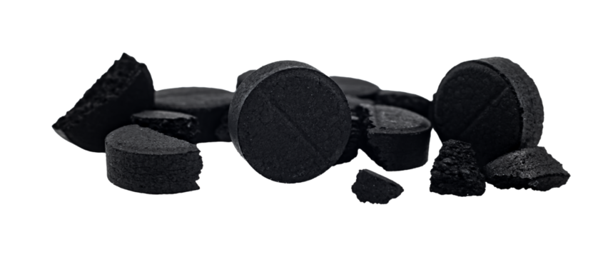 Coal. Black activated carbon tablets on a white background. Health. View from above