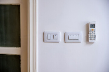 White House wall consist of electrical switches with Air conditioning remote