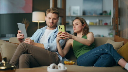 Serious woman showing mobile phone to boyfriend. Involved spouses using devices