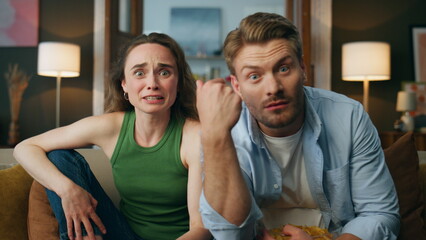 Excited spouses supporting soccer indoors pov. Euphoric couple celebrating goal