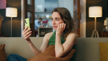 Sad lady talking smartphone home sofa. Depressed woman complaining video chat 