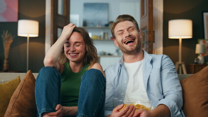 Overjoyed pair laughing comedy watching television pov. Spouses reacting at joke