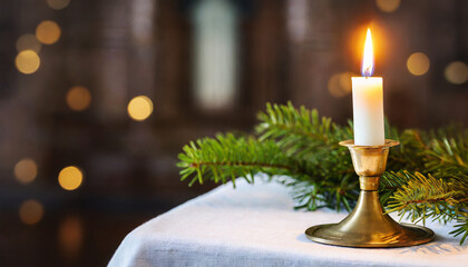 Candle with brass holder burning with church background 