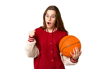 Teenager girl playing basketball over isolated chroma key background celebrating a victory in...