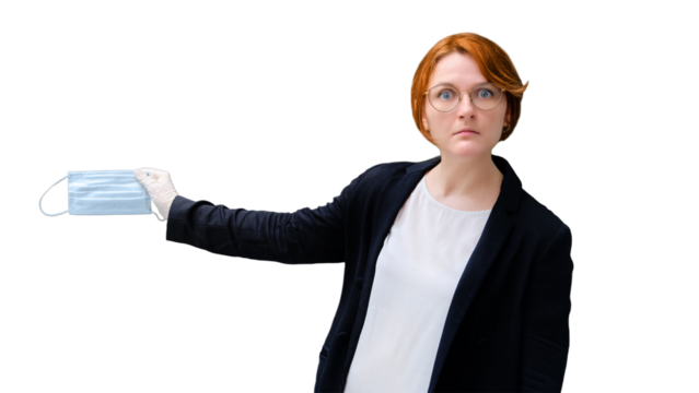 Teacher sadly holds a medical mask near the school blackboard, isolated on a white background. Quarantine concept at school due to coronavirus epidemic, copy space green background