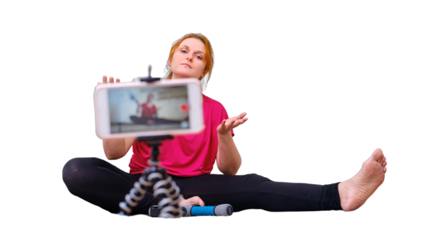 A female blogger films a sports training lesson in front of a phone camera in a home kitchen, isolated on a white background. Independent fitness in the home on isolation due to the coronavirus - Powered by Adobe