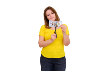 A woman in an empty house cuts dollars, isolated on a white background. The concept of wasted money, taxes and difficulty paying for housing.