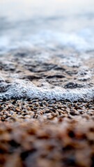Macro abstract shot of foam, calm sea waves and small rocks on a sea beach