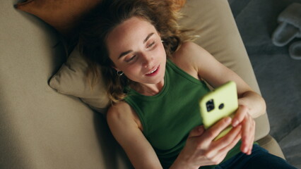 Carefree girl talking phone call apartment closeup. Smiling woman laying couch
