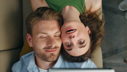 Love couple taking selfie laying sofa top view. Loving pair trying face mask app