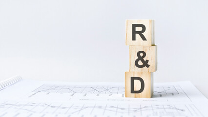 text R and D on wooden cube blocks stack on wood table on white background with copy space