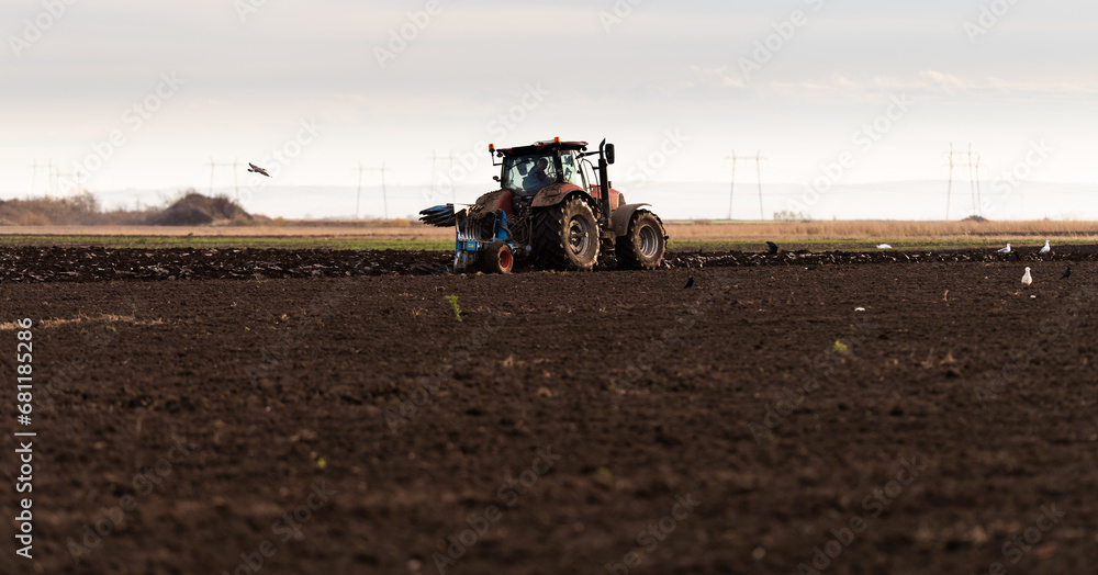 Wall mural tractor on the field during sunset.