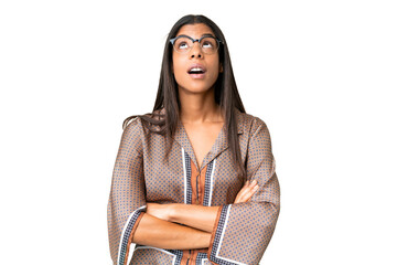 Young African American woman over isolated chroma key background looking up and with surprised...